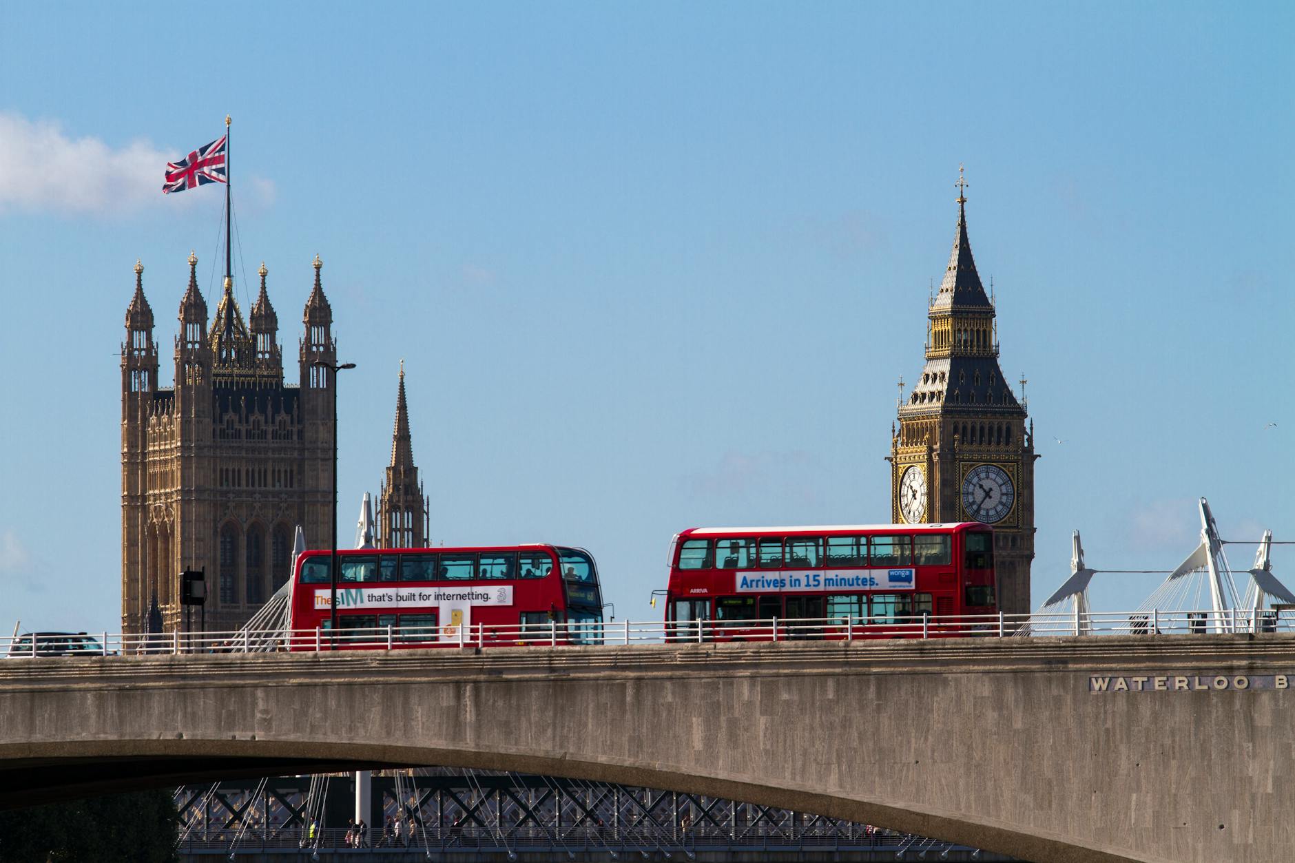 Czerwone autobusy piętrowe na moście Waterloo, w tle Big Ben i parlament