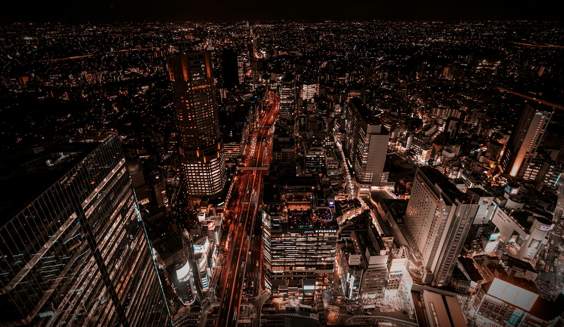 Nocna panorama Tokio z oświetlonymi wieżowcami i ruchliwymi ulicami
