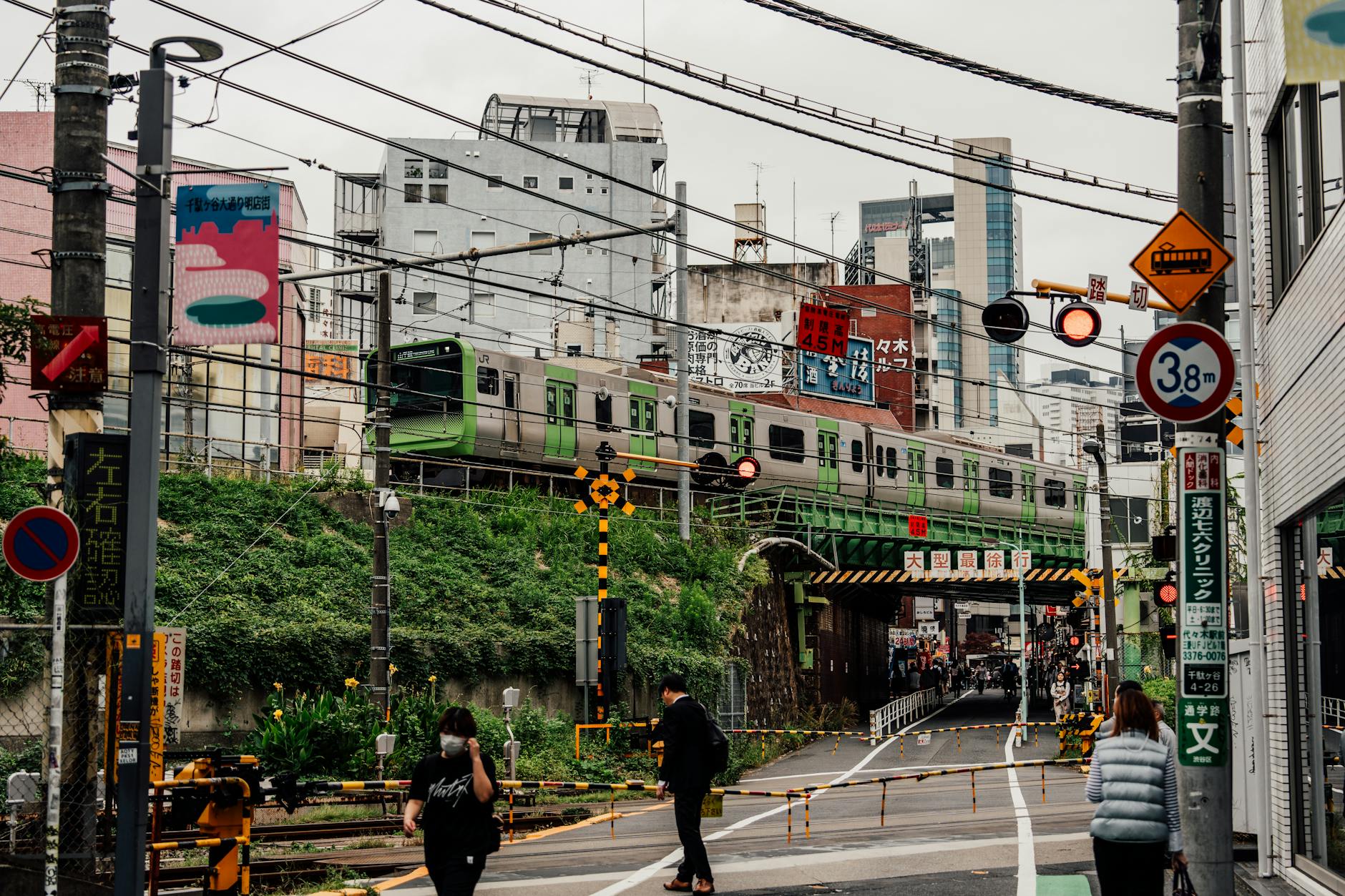 Ruchliwa ulica w Tokio z pociągiem przejeżdżającym nad pieszymi